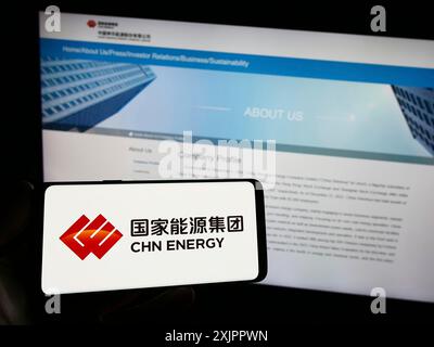 Stuttgart, Deutschland, 16.08.2023: Person, die ein Smartphone mit dem Logo des Unternehmens China Energy Investment Corporation auf dem Bildschirm vor der Website hält. Stockfoto