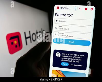 Stuttgart, Deutschland, 18.08.2023: Person, die ein Mobiltelefon hält, mit Webseite der US-Hotelbuchungsgesellschaft Hotels.com LP auf dem Bildschirm vor dem Logo. Konzentrieren Sie sich auf Stockfoto