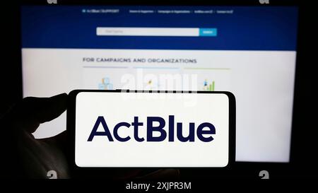 Stuttgart, 20.08.2023: Person, die ein Mobiltelefon mit dem Logo der Fundraising-Organisation ActBlue Charities Inc. Auf dem Bildschirm vor der Webseite hält. Stockfoto