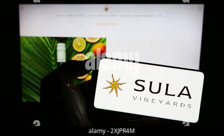 Stuttgart, Deutschland, 20.08.2023: Person, die ein Mobiltelefon mit dem Logo der indischen Weinkellerei Sula Vineyards auf dem Bildschirm vor der Webseite hält. Stockfoto
