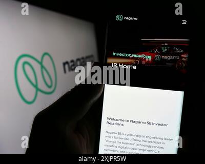 Stuttgart, Deutschland, 20.08.2023: Person, die ein Mobiltelefon hält, mit Webseite des IT-Unternehmens Nagarro SE vor dem Logo auf dem Bildschirm. Fokus Stockfoto