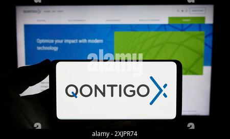 Stuttgart, Deutschland, 20.08.2023: Person, die ein Smartphone mit dem Logo des deutschen Finanzdatenunternehmens Qontigo GmbH auf dem Bildschirm vor der Website hält. Stockfoto