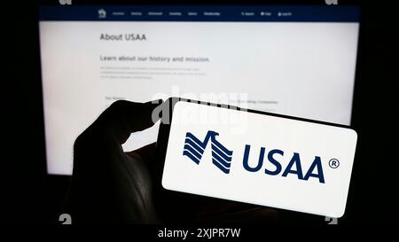 Stuttgart, Deutschland, 20.08.2023: Person, die ein Smartphone mit dem Logo der United Services Automobile Association (USAA) auf dem Bildschirm vor der Website hält. Stockfoto