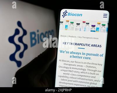 Stuttgart, Deutschland, 26.08.2023: Person, die ein Smartphone hält, mit der Webseite des indischen biopharmazeutischen Unternehmens Biocon Limited auf dem Bildschirm mit Logo. Fokus Stockfoto