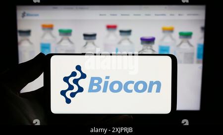 Stuttgart, Deutschland, 26.08.2023: Person mit Smartphone und Logo des indischen biopharmazeutischen Unternehmens Biocon Limited auf dem Bildschirm vor der Website. Stockfoto