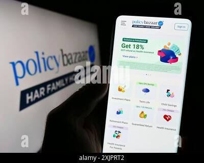 Stuttgart, Deutschland, 08-30-2023: Person, die ein Handy hält, mit Webseite der indischen Finanzplattform Policybazaar vor dem Logo auf dem Bildschirm. Konzentrieren Sie sich auf Stockfoto