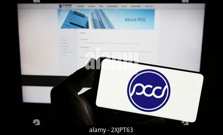 Stuttgart, Deutschland, 09.05.2023: Person, die ein Smartphone mit dem Logo des taiwanesischen Schuhunternehmens Pou Chen Corporation auf dem Bildschirm vor der Website hält. Stockfoto