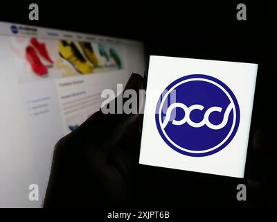 Stuttgart, Deutschland, 09.05.2023: Person, die ein Handy hält, mit Website des taiwanesischen Schuhunternehmens Pou Chen Corporation auf dem Bildschirm mit Logo. Fokus Stockfoto