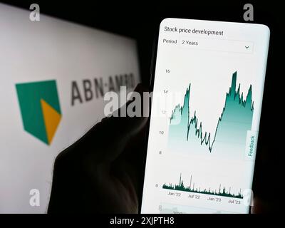 Stuttgart, Deutschland, 09.11.2023: Person, die ein Smartphone hält, mit Website der niederländischen Finanzgesellschaft ABN AMRO Bank N.V. auf dem Bildschirm vor dem Logo. Stockfoto