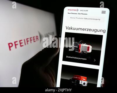 Stuttgart, Deutschland, 09.10.2023: Handybesitzer mit Webseite der deutschen Firma Pfeiffer Vacuum Technology AG auf dem Bildschirm mit Logo. Konzentrieren Sie sich auf Stockfoto