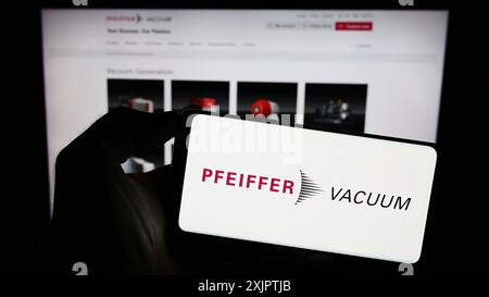 Stuttgart, Deutschland, 09.10.2023: Person mit Smartphone mit Logo der deutschen Pfeiffer Vacuum Technology AG auf dem Bildschirm vor der Website. Stockfoto