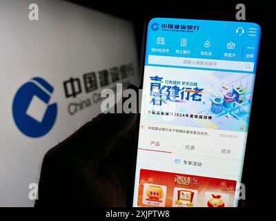 Stuttgart, Deutschland, 17.09.2023: Person, die ein Smartphone hält, auf der Webseite der Firma China Construction Bank Corporation (CCB) mit Logo angezeigt wird. Stockfoto