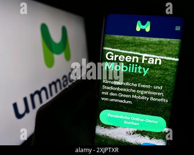 Stuttgart, Deutschland, 17.09.2023: Person, die ein Mobiltelefon hält, mit Webseite der österreichischen Benefizgesellschaft Ummadum Service GmbH auf dem Bildschirm mit Logo. Konzentrieren Sie sich auf Stockfoto