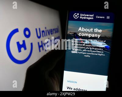 Stuttgart, Deutschland, 18.09.2023: Person, die ein Mobiltelefon hält, mit der Webseite des US-amerikanischen Luftfahrtunternehmens Universal Hydrogen Co. Vor dem Logo auf dem Bildschirm. Stockfoto