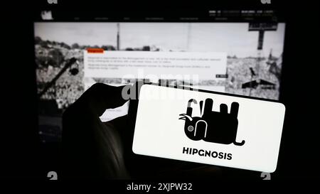 Stuttgart, Deutschland, 18.09.2023: Person, die ein Smartphone mit dem Logo der Investmentgesellschaft Hipgnosis Songs Fund Limited auf dem Bildschirm vor der Website hält. Stockfoto