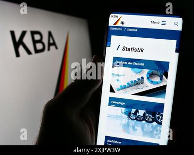 Stuttgart, 17.09.2023: Handybesitzer mit Webseite des Kraftfahrt-Bundesamtes (KBA) auf dem Bildschirm mit Logo. Fokus Stockfoto