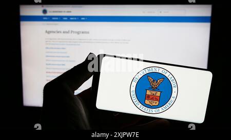 Stuttgart, Deutschland, 20.09.2023: Person, die ein Smartphone mit dem Siegel des United States Department of Labor (US DOL) auf dem Bildschirm vor der Website hält. Stockfoto