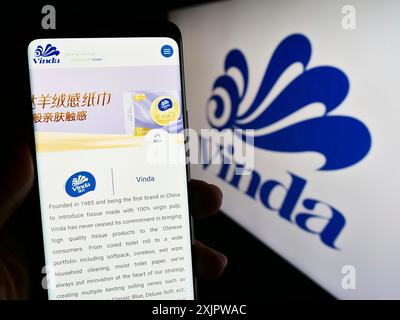 Stuttgart, Deutschland, 21.09.2023: Person, die ein Mobiltelefon hält, mit Webseite der Firma Vinda International Holdings Limited auf dem Bildschirm mit Logo. Konzentrieren Sie sich auf Stockfoto