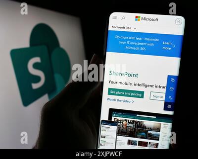 Stuttgart, Deutschland, 21.09.2023: Person, die ein Smartphone hält, mit Website der kollaborativen Plattform Microsoft SharePoint auf dem Bildschirm mit Logo. Konzentrieren Sie sich auf Stockfoto