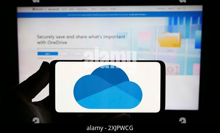 Stuttgart, Deutschland, 21.09.2023: Person, die ein Smartphone mit dem Logo des Datei-Hosting-Dienstes Microsoft OneDrive auf dem Bildschirm vor der Website hält. Fokus Stockfoto