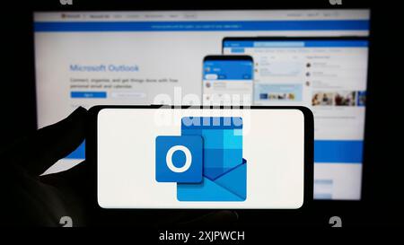 Stuttgart, Deutschland, 21.09.2023: Person, die ein Smartphone mit dem Logo der E-Mail-Software Microsoft Outlook auf dem Bildschirm vor der Website hält. Konzentrieren Sie sich auf das Telefon Stockfoto