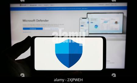 Stuttgart, Deutschland, 21.09.2023: Person, die ein Smartphone mit dem Logo der Sicherheitssoftware Microsoft Defender Antivirus auf dem Bildschirm vor der Website hält. Stockfoto