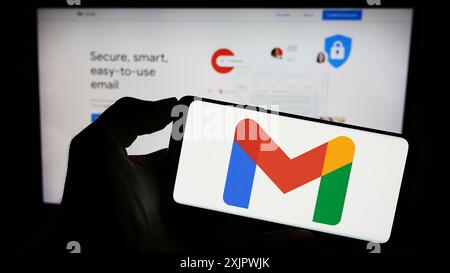 Stuttgart, Deutschland, 23.09.2023: Person, die ein Mobiltelefon mit dem Logo des E-Mail-Dienstes Google Gmail auf dem Bildschirm vor der Business-Webseite hält. Konzentrieren Sie sich auf Stockfoto