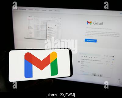 Stuttgart, Deutschland, 23.09.2023: Person, die ein Mobiltelefon mit dem Logo des E-Mail-Dienstes Google Gmail auf dem Bildschirm vor der Website des Unternehmens hält. Konzentrieren Sie sich auf Stockfoto