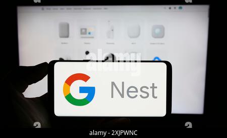 Stuttgart, Deutschland, 23.09.2023: Person, die ein Mobiltelefon mit dem Logo der Smart-Home-Plattform Google Nest auf dem Bildschirm vor der Business-Website hält. Fokus Stockfoto