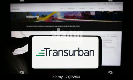 Stuttgart, 24.09.2023: Person, die ein Mobiltelefon mit dem Logo des Infrastrukturunternehmens Transurban Limited vor dem Geschäft auf dem Bildschirm hält Stockfoto