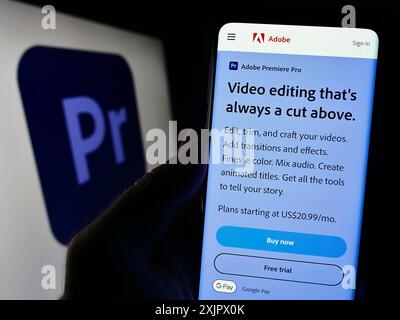 Stuttgart, 23.09.2023: Person, die ein Mobiltelefon hält, auf dem die Webseite der Videobearbeitungssoftware Adobe Premiere Pro vor dem Logo angezeigt wird. Fokus Stockfoto
