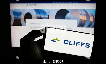 Stuttgart, 25.09.2023: Person, die ein Smartphone mit dem Logo des US-amerikanischen Stahlunternehmens Cleveland-Cliffs Inc. Vor der Website hält. Konzentrieren Sie sich auf das Telefon Stockfoto