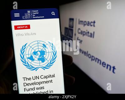 Stuttgart, Deutschland, 25.09.2023: Person, die ein Smartphone hält, mit Website des Fonds der Vereinten Nationen für Kapitalentwicklung (UNCDF) vor dem Logo. Konzentrieren Sie sich auf Stockfoto