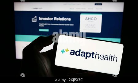 Stuttgart, Deutschland, 25.09.2023: Person, die ein Smartphone mit dem Logo des US-amerikanischen Gesundheitsunternehmens AdaptHealth LLC vor der Website hält. Konzentrieren Sie sich auf das Telefon Stockfoto
