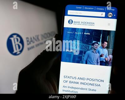 Stuttgart, Deutschland, 13.10.2023: Person mit Smartphone und Website des indonesischen Finanzinstituts Bank Indonesia (BI) vor dem Logo. Stockfoto