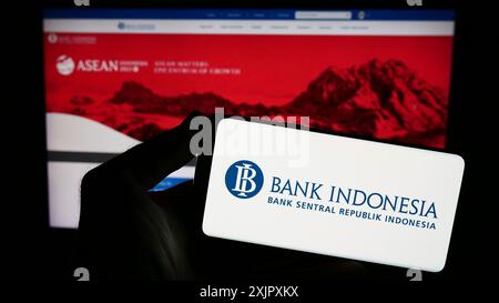 Stuttgart, Deutschland, 13.10.2023: Person mit Smartphone mit Logo des indonesischen Finanzinstituts Bank Indonesia (BI) vor der Website. Stockfoto