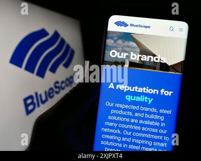 Stuttgart, 16.10.2023: Person, die ein Mobiltelefon hält, mit Webseite des australischen Unternehmens BlueScope Steel Limited vor dem Logo. Konzentrieren Sie sich auf die Mitte Stockfoto