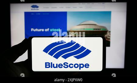 Stuttgart, 16. 10. 2023: Person, die ein Smartphone mit dem Logo des australischen Unternehmens BlueScope Steel Limited vor der Website hält. Konzentrieren Sie sich auf das Telefon Stockfoto