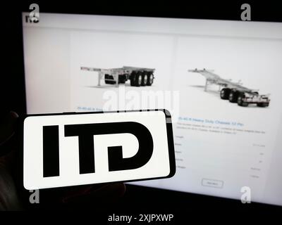 Stuttgart, 16.10.2023: Person, die ein Mobiltelefon mit dem Logo des kanadischen Trailer-Unternehmens ITD Industries Inc. Vor der Webseite hält. Stockfoto