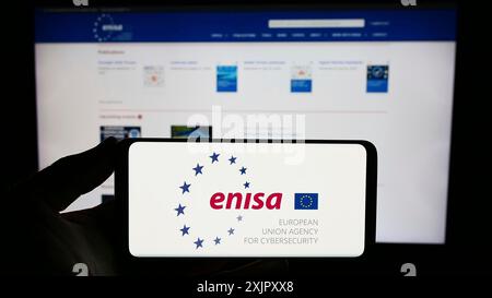 Stuttgart, Deutschland, 16.10.2023: Person, die ein Smartphone mit dem Logo der Agentur der Europäischen Union für Cybersicherheit (ENISA) vor der Website hält. Konzentrieren Sie sich auf Stockfoto