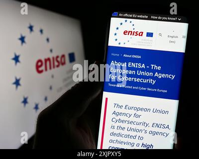 Stuttgart, Deutschland, 16.10.2023: Person, die ein Mobiltelefon hält, mit Website der Agentur der Europäischen Union für Cybersicherheit (ENISA) vor dem Logo. Konzentrieren Sie sich auf Stockfoto