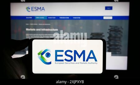 Stuttgart, Deutschland, 20. 10. 2023: Person mit Mobiltelefon mit Logo der Europäischen Wertpapier- und Marktaufsichtsbehörde (ESMA) vor der Webseite. Konzentrieren Sie sich auf Stockfoto