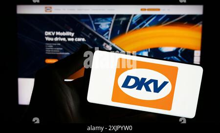 Stuttgart, Deutschland, 11.02.2023: Person mit Smartphone mit Logo des deutschen B2B-Zahlungsunternehmens DKV Mobility vor der Website. Konzentrieren Sie sich auf das Telefon Stockfoto