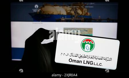 Stuttgart, Deutschland, 11.06.2023: Person, die ein Mobiltelefon mit dem Logo des omanischen Flüssigerdgasunternehmens Oman LNG vor der Webseite hält. Stockfoto