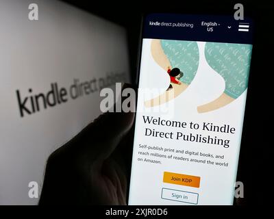 Stuttgart, Deutschland, 11.09.2023: Person mit Mobiltelefon mit Website der Amazon E-Book-Plattform Kindle Direct Publishing (KDP) mit Logo. Konzentrieren Sie sich auf Stockfoto