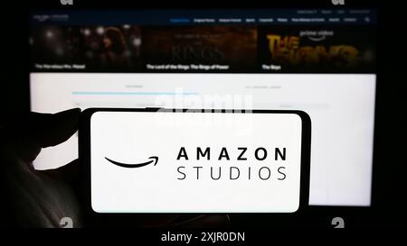 Stuttgart, Deutschland, 11.08.2023: Person mit Handy mit Logo der amerikanischen Film- und Fernsehproduktionsfirma Amazon Studios vor Stockfoto