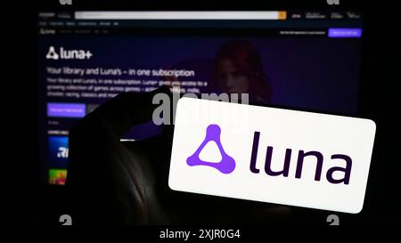 Stuttgart, Deutschland, 11.08.2023: Person mit Smartphone mit Logo der US-Cloud-Gaming-Plattform Amazon Luna vor der Website. Konzentrieren Sie sich auf das Telefon Stockfoto
