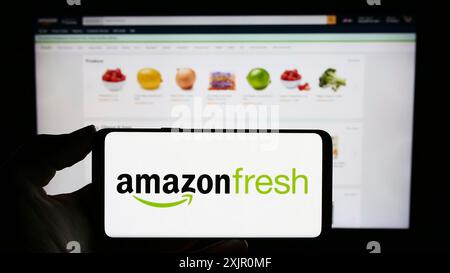 Stuttgart, Deutschland, 11.09.2023: Person, die ein Mobiltelefon mit dem Logo des US-amerikanischen Lebensmitteleinzelhandelsunternehmens Amazon Fresh vor der Webseite hält. Konzentrieren Sie sich auf Stockfoto