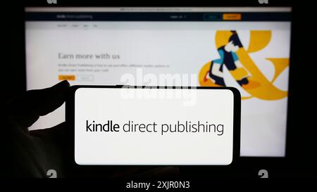 Stuttgart, Deutschland, 11.09.2023: Person, die ein Smartphone mit dem Logo der Amazon E-Book-Plattform Kindle Direct Publishing (KDP) vor der Website hält. Stockfoto