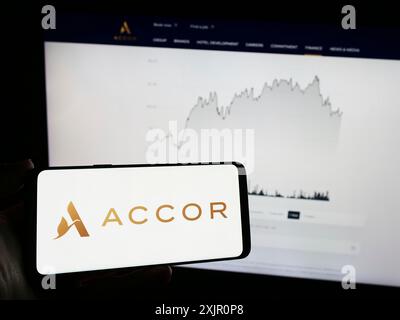 Stuttgart, Deutschland, 11.10.2023: Person, die ein Mobiltelefon mit dem Logo des französischen Gastgewerbeunternehmens Accor SA vor der Business-Webseite hält. Konzentrieren Sie sich auf Stockfoto